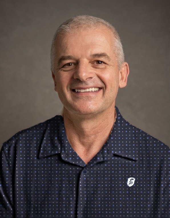 Portrait de Stéphane Sédano, souriant, chemise bleu marine